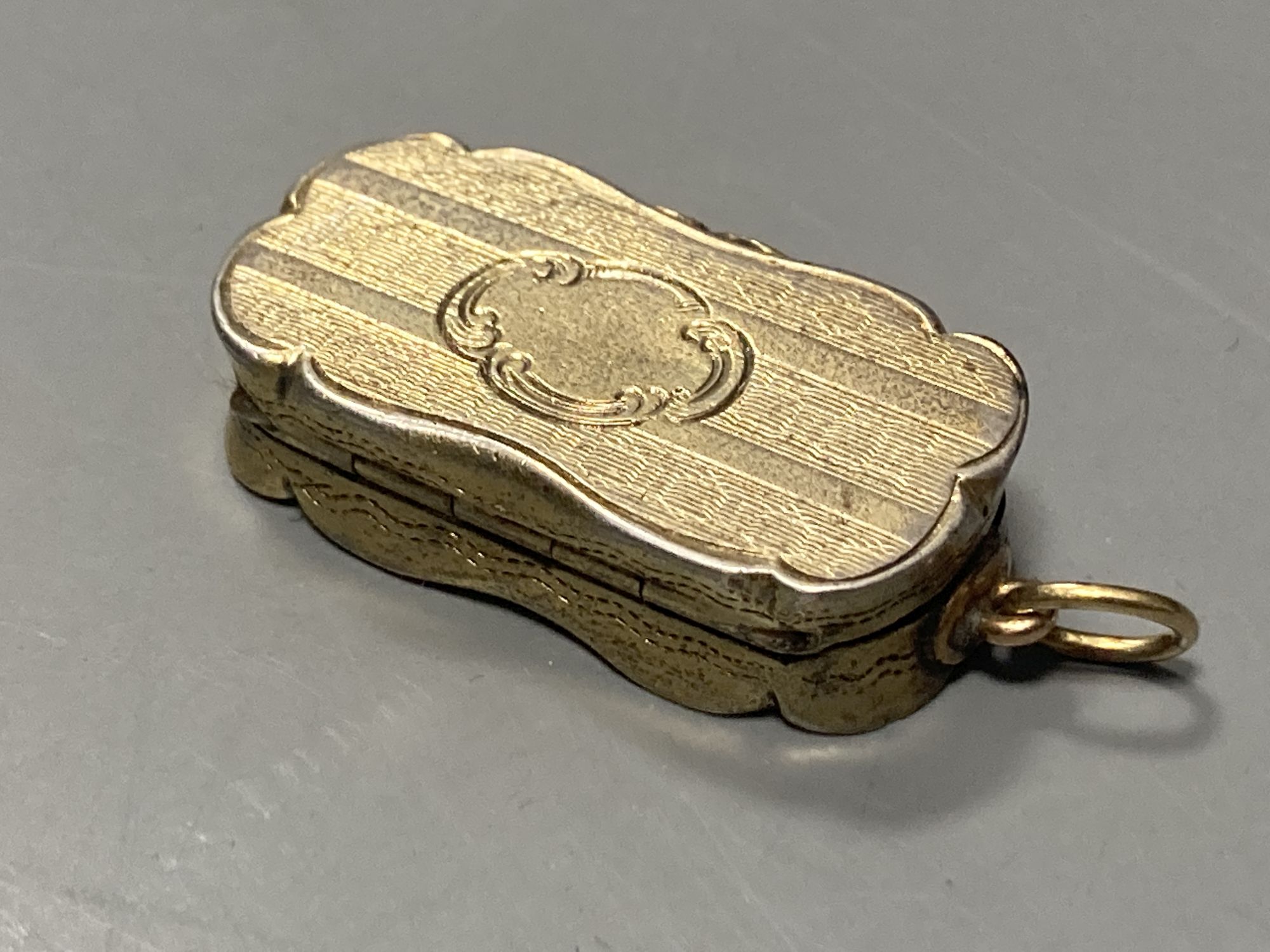 A Victorian silver gilt shaped ovoid vinaigrette, Abraham Kemp, Birmingham, 1853, 33mm.